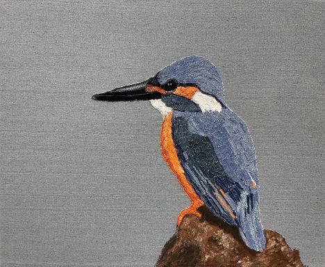 Blauwe ijsvogel zit op een rots met grijze achtergrond.