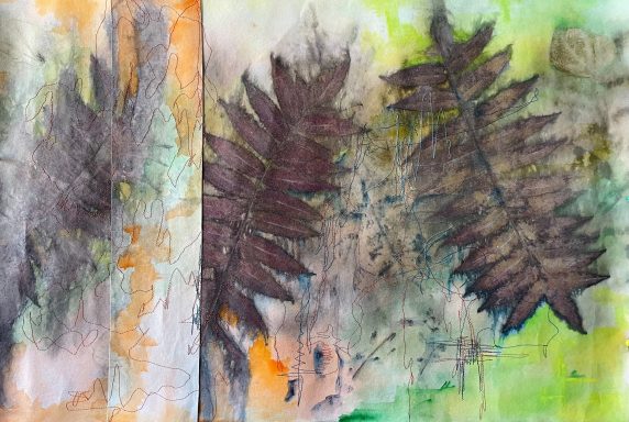 Abstract kunstwerk met verf en bladeren in aardetinten en groene achtergrond.
